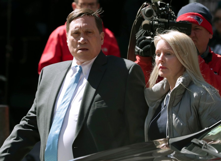 Investor John Wilson, left, arrives at federal court in Boston with his wife Leslie in this Wednesday, April 3, 2019 file photo, to face charges in a nationwide college admissions bribery scandal. The first trial in the college admissions bribery scandal opened Monday, Sept. 13, 2021, with defense attorneys seeking to portray the two parents accused of buying their kids' way into school as victims of deception who believed their payments were legal donations. (AP Photo/Charles Krupa, File)