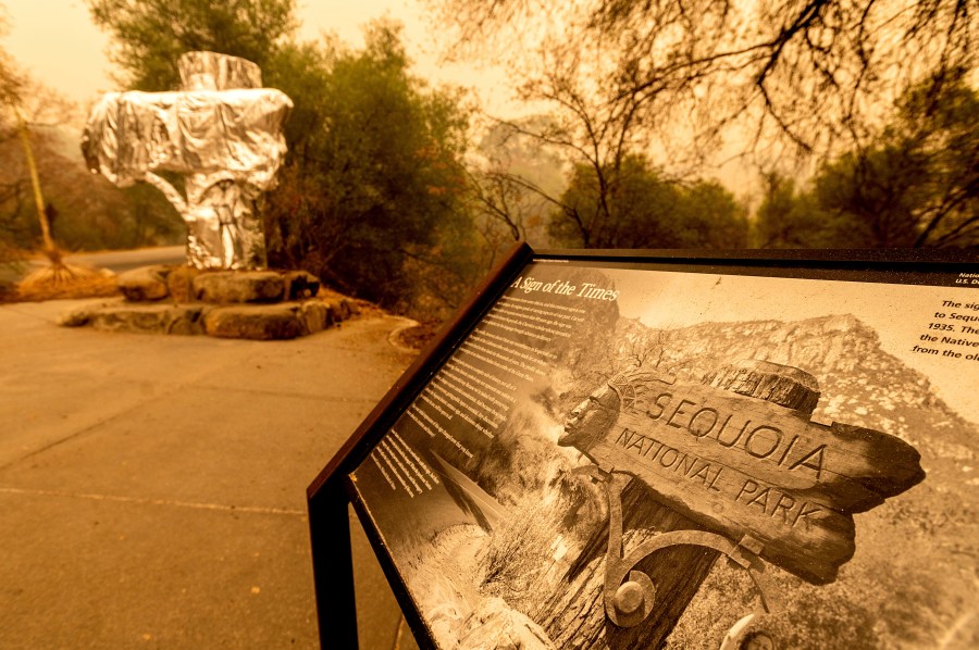 Fire-resistant wrap covers a historic welcome sign as the KNP Complex Fire burns in Sequoia National Park, Calif., on Wednesday, Sept. 15, 2021. The blaze is burning near the Giant Forest, home to more than 2,000 giant sequoias. (AP Photo/Noah Berger)