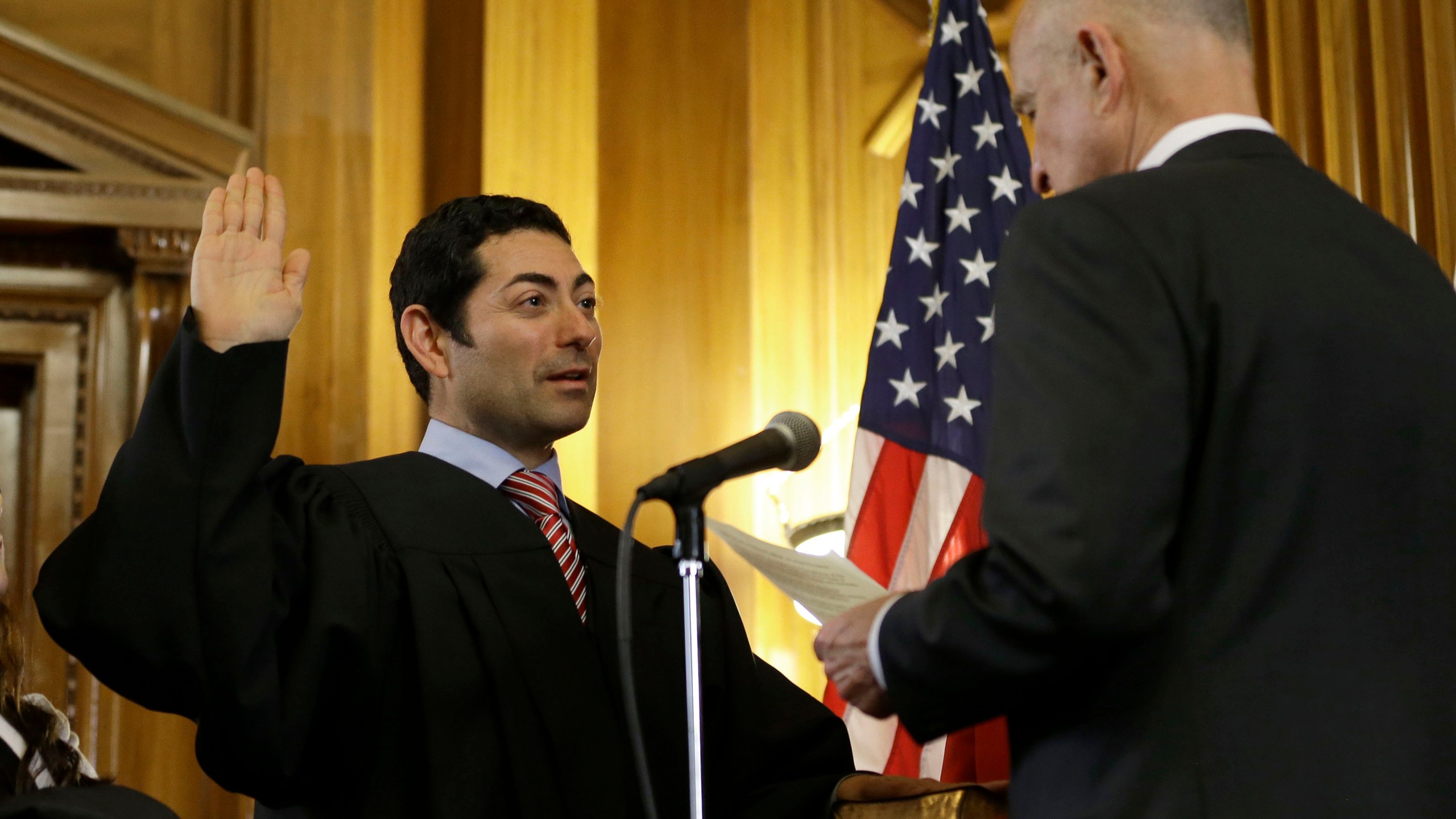 In this Jan. 5, 2015 file photo Mariano-Florentino Cuellar, left, is sworn in as an associate justice to the California Supreme Court by Gov. Jerry Brown during an inauguration ceremony in Sacramento. (Rich Pedroncelli/Associated Press)