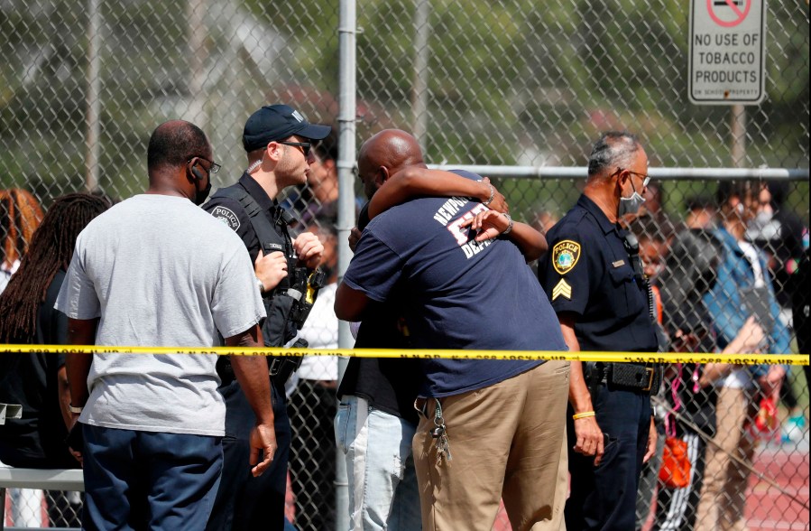 People embrace outside Heritage High School as Newport News Police are on scene responding to a shooting incident Monday, Sept. 20, 2021 in Newport News, Va. (Jonathon Gruenke/The Virginian-Pilot via AP)