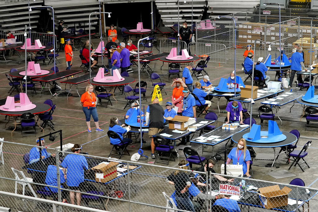 In this May 6, 2021, file photo, Maricopa County ballots cast in the 2020 general election are examined and recounted by contractors working for Florida-based company, Cyber Ninjas at Veterans Memorial Coliseum in Phoenix. (AP Photo/Matt York, Pool, File)