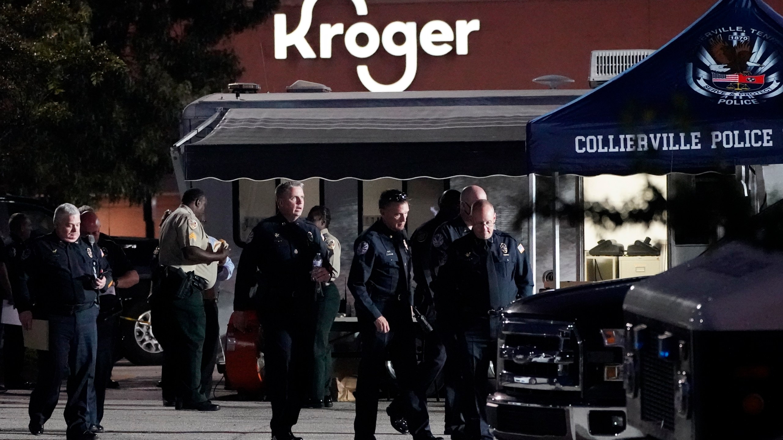 Law enforcement personnel work in front of a Kroger grocery store as an investigation goes into the night following a shooting earlier in the day on Thursday, Sept. 23, 2021, in Collierville, Tenn. Police say a gunman attacked people in the store and killed at least one person and wounded 12 others before the suspect was found dead. (AP Photo/Mark Humphrey)