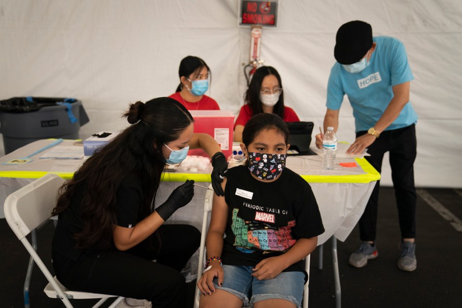 In this Aug. 28, 2021, file photo, Mayra Navarrete, 13, receives the Pfizer COVID-19 vaccine from registered nurse, Noleen Nobleza at a clinic set up in the parking lot of CalOptima in Orange, Calif. (AP Photo/Jae C. Hong, File)