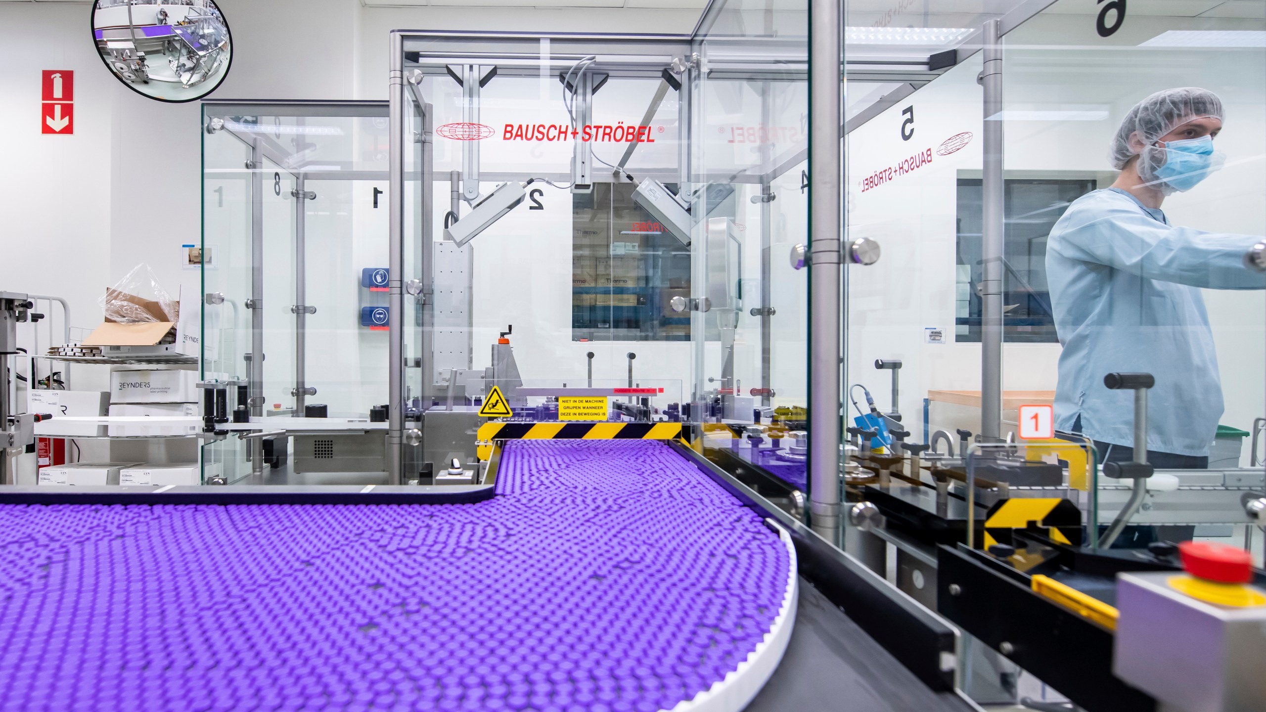 In this March 2021 photo provided by Pfizer, a technician works on a line for packaging preparation for the Pfizer-BioNTech COVID-19 vaccine at the company's facility in Puurs, Belgium. (Pfizer via AP)