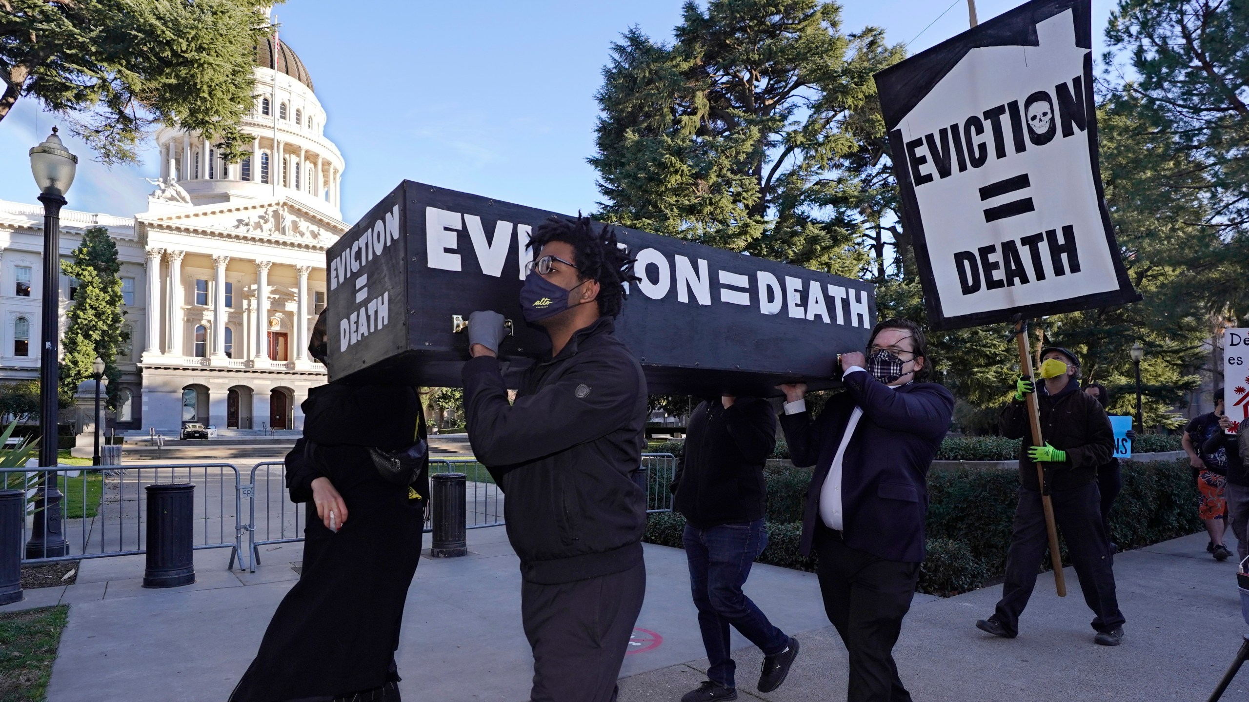 Demonstrators call for passage of rent forgiveness and stronger eviction protections legislation as they carry a mock casket past the Capitol in Sacramento on Jan. 25, 2021. (Rich Pedroncelli / Associated Press)