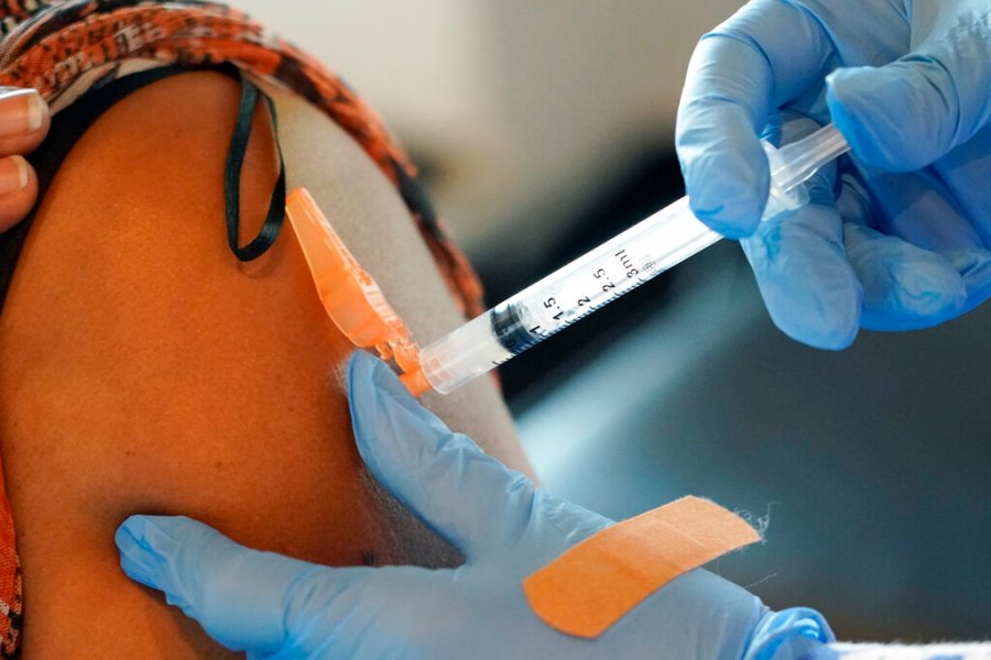 In this Sept. 21, 2021, file photo, Jackson-Hinds Comprehensive Health Center nurse Maggie Bass, right, injects a COVID-19 vaccine into an arm in Jackson, Miss. (AP Photo/Rogelio V. Solis, File)