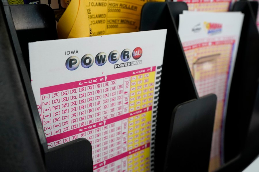 In this Jan. 12, 2021 file photo, blank forms for the Powerball lottery sit in a bin at a local grocery store, in Des Moines, Iowa. (AP Photo/Charlie Neibergall)