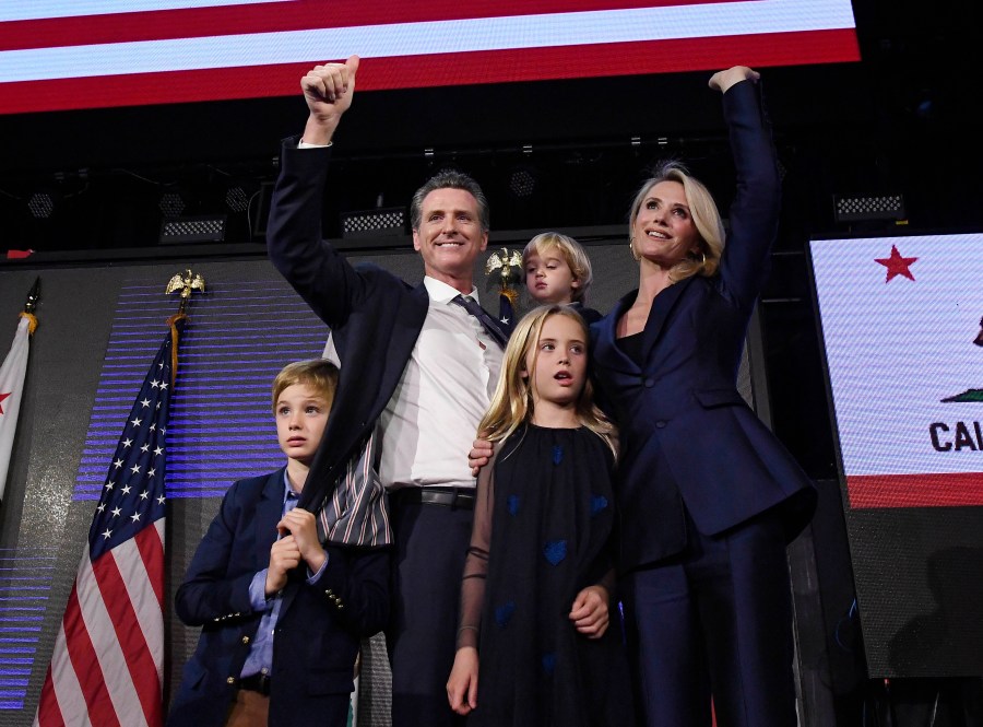 A newly elected Gov. Gavin Newsom holds his son Dutch, 2, and stands with his son Hunter, 7, wife Jennifer Siebel Newsom and daughter Montana, 9, as he waves to supporters during election night event in Los Angeles on Nov. 6, 2018. (Kevork Djansezian / Getty Images)