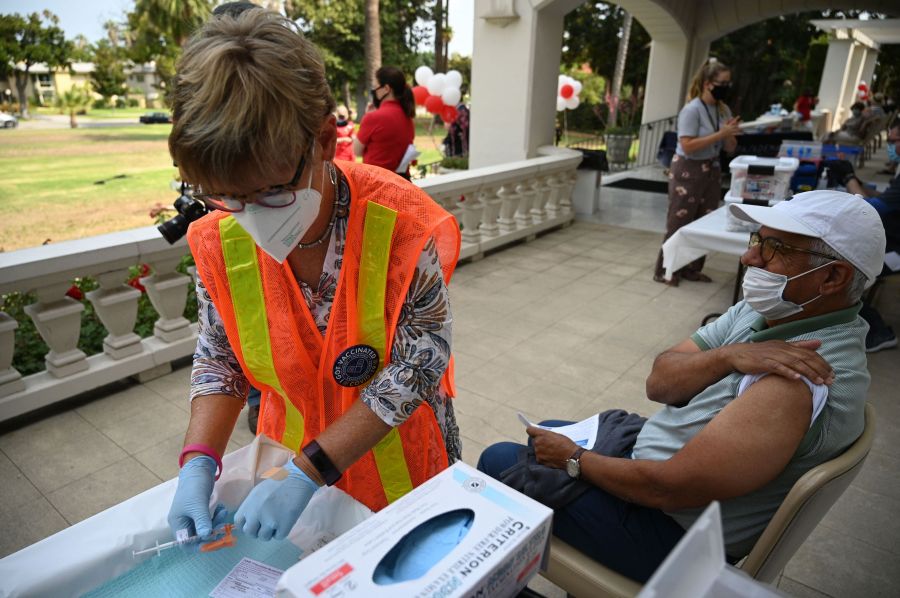 A nurse prepares a first dose of the Pfizer COVID-19 vaccine for Jose Luis Sanchez at a clinic hosted by The Tournament of Roses in partnership with the Pasadena Public Health Department on Aug. 19, 2021, at Tournament House in Pasadena. (Robyn Beck / AFP / Getty Images)