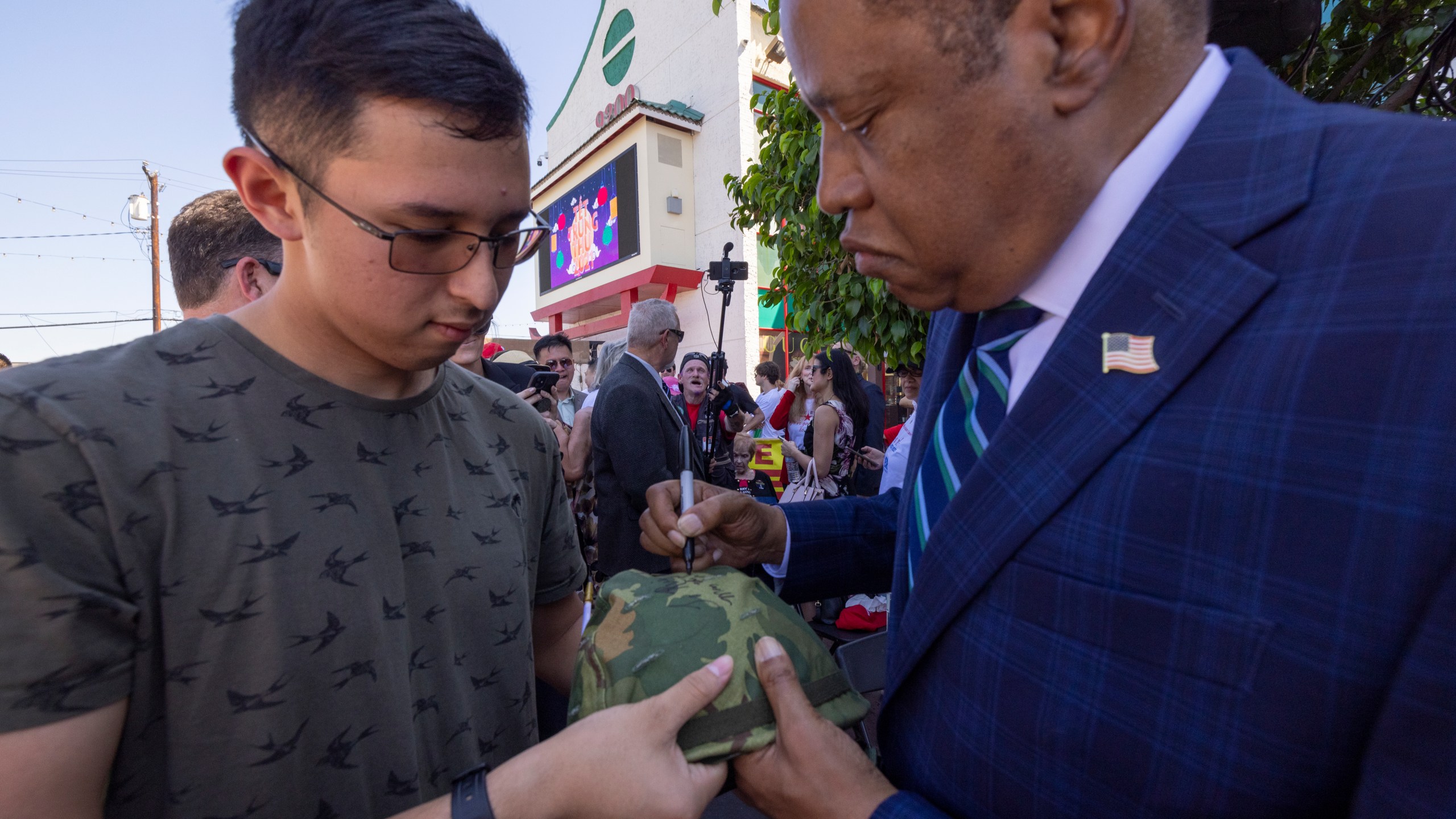 Republican recall candidate Larry Elder signs the helmet of U.S. Navy ETSN Daniel Luiz at the "Asian Rally for Yes on Recall" at the Asian Garden Mall on Sept. 4, 2021, in Westminster. (David McNew/Getty Images)