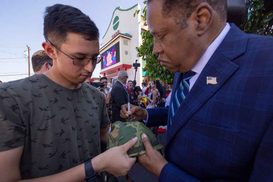 Republican recall candidate Larry Elder signs the helmet of U.S. Navy ETSN Daniel Luiz at the "Asian Rally for Yes on Recall" at the Asian Garden Mall on Sept. 4, 2021, in Westminster. (David McNew/Getty Images)