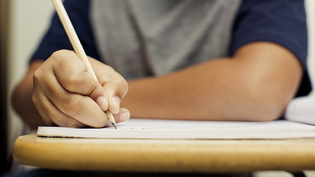 A student writes at a desk in this undated file photo. (Getty Images)