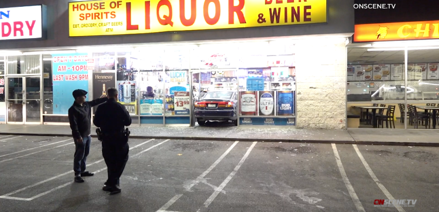 An Anaheim police officer interviews a witness after a man crashed into a liquor store and tried to rob patrons on Sept. 1, 2021. (OnScene.TV)