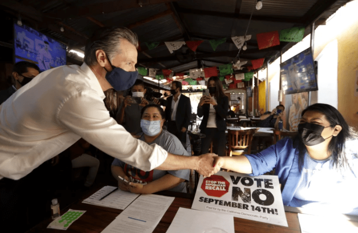 Gov. Gavin Newsom greets volunteers working phone banks in support of voting against the recall on Aug. 14 at Hecho en Mexico restaurant in East Los Angeles.(Genaro Molina / Los Angeles Times)