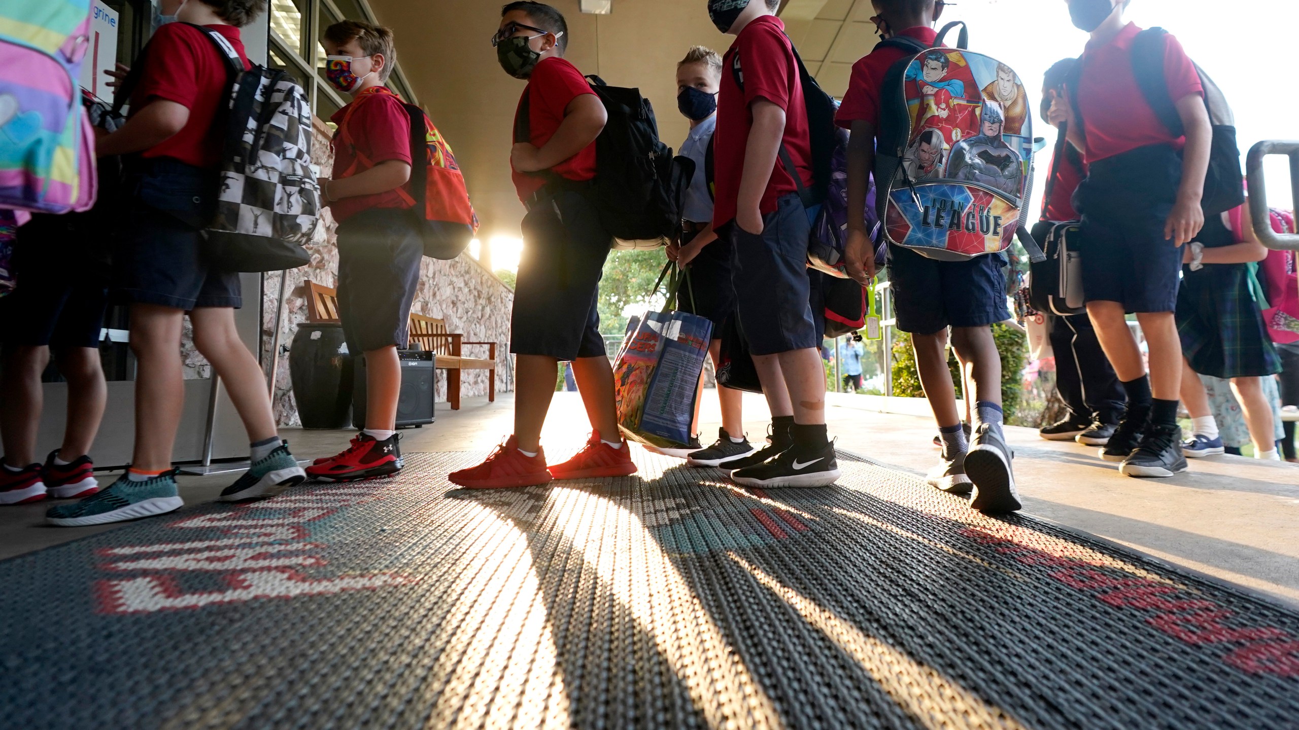 Wearing masks to prevent the spread of COVID-19, elementary school students line up to enter school for the first day of classes in Richardson, Texas, Tuesday, Aug. 17, 2021. (AP Photo/LM Otero)