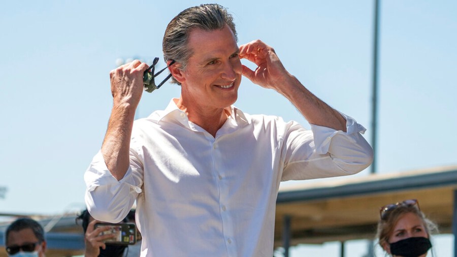 In this Sept. 4, 2021, photo, California Gov. Gavin Newsom takes his face mask off before addressing hundreds of supporters at a campaign event against the California recall election at Culver City High School in Culver City. (AP Photo/Damian Dovarganes)