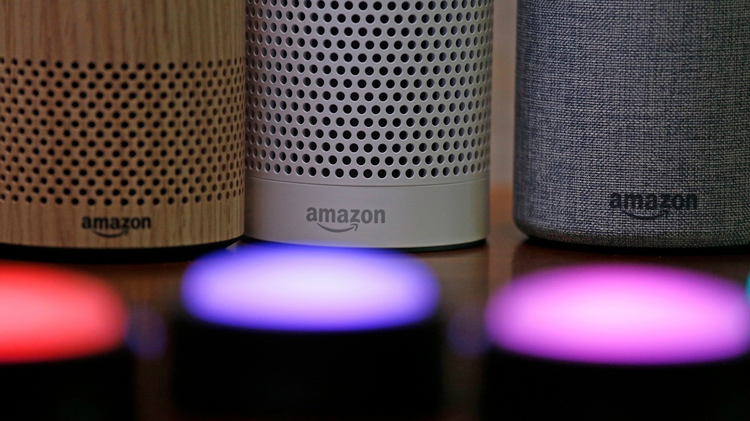 In this Sept. 27, 2017, file photo, Amazon Echo and Echo Plus devices, behind, sit near illuminated Echo Button devices during an event announcing several new Amazon products by the company in Seattle. Users of Amazon's Alexa digital assistant can now request that recordings of their voice commands delete automatically. (AP Photo/Elaine Thompson, File)