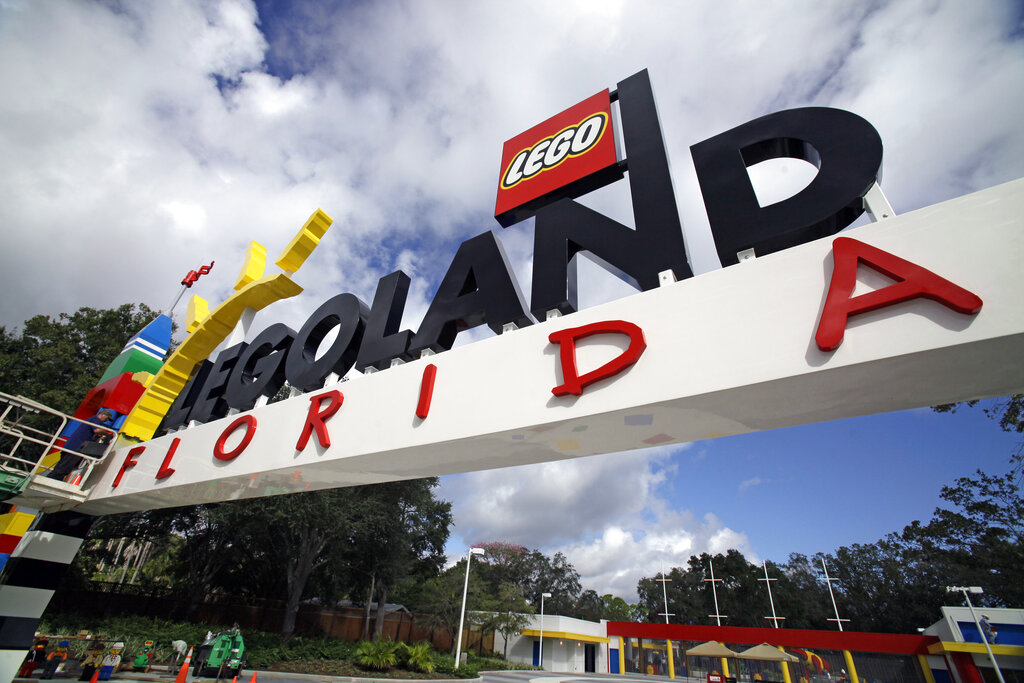 In this Tuesday, Sept. 27, 2011, file photo, a worker puts finishing touches on the entrance sign at Legoland Florida in Winter Haven, Fla. AP Photo/John Raoux, File)