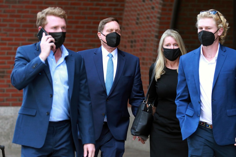 John Wilson, second left, holds his wife's hand, second right, as he leaves the John Joseph Moakley Federal Courthouse after the first day of his trial in the college admissions scandal on Sept.13, 2021, in Boston. (AP Photo/Stew Milne)