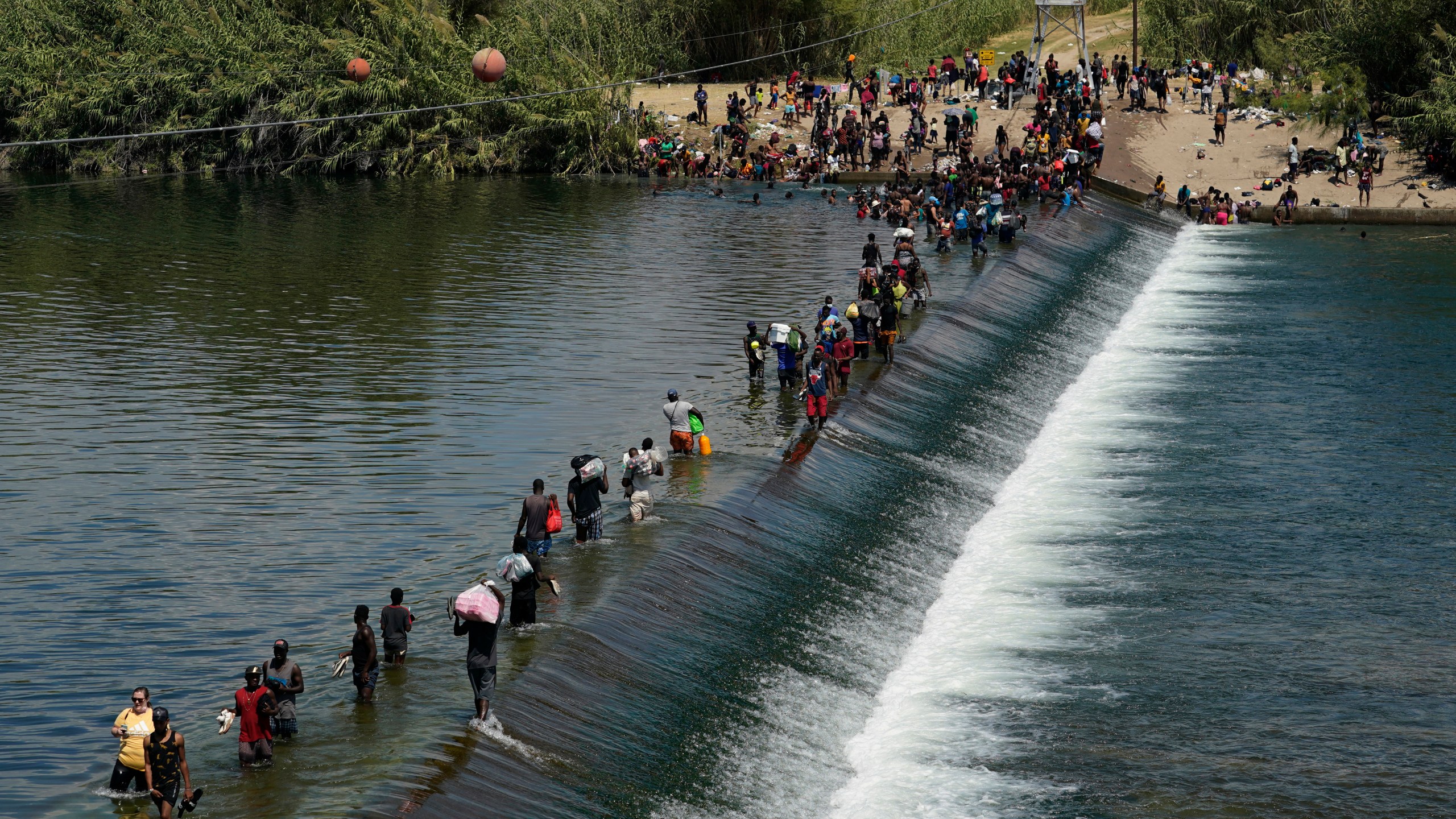 Haitian migrants use a dam to cross into the U.S. from Mexico in Del Rio, Texas, on Sept. 18, 2021. (Eric Gay / Associated Press)