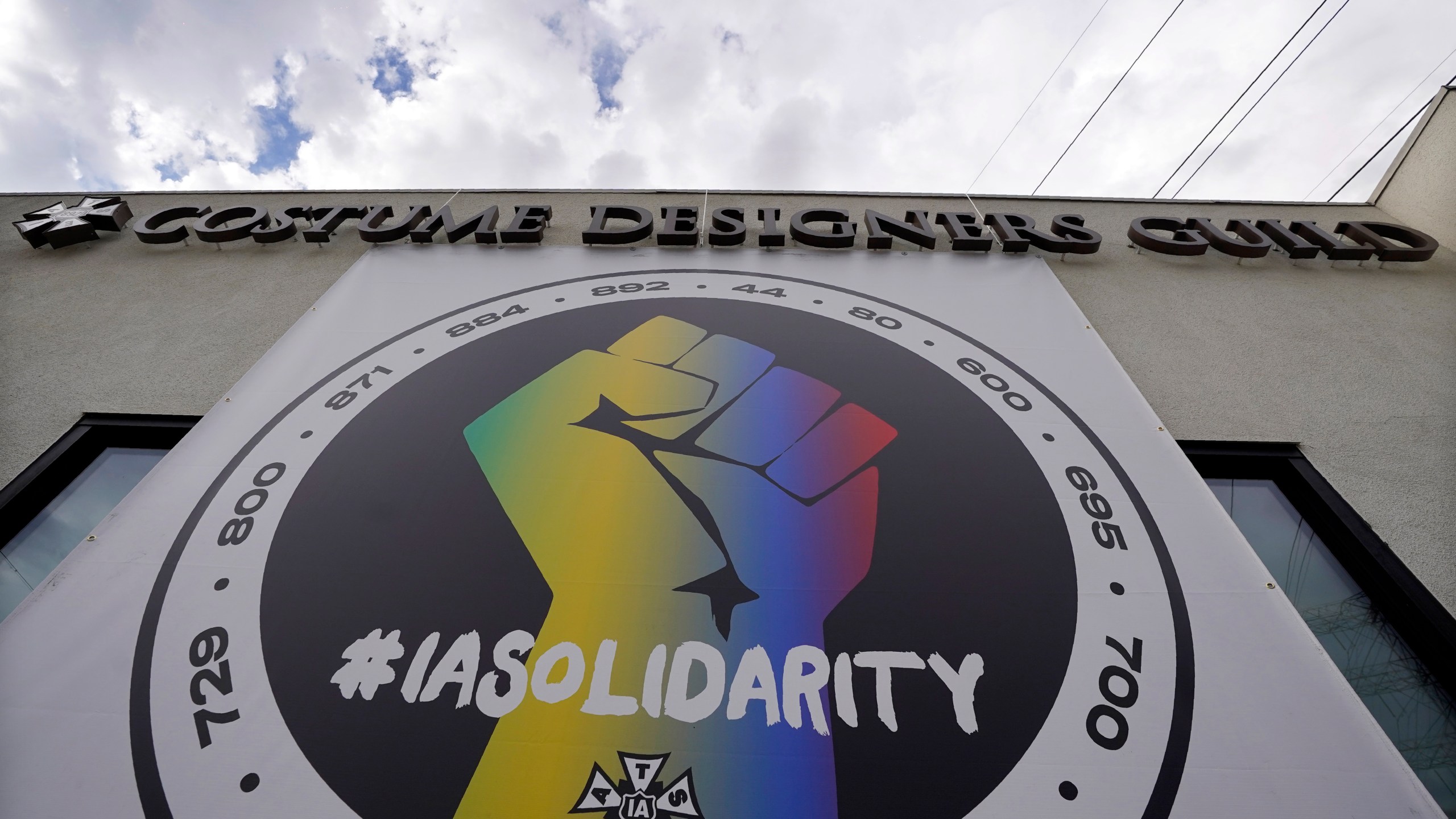 A poster advocating union solidarity hangs from a Costume Designers Guild office building, Monday, Oct. 4, 2021, in Burbank, Calif. The International Alliance of Theatrical Stage Employees (IATSE) overwhelmingly voted to authorize a strike for the first time in its 128-year history. (AP Photo/Chris Pizzello)