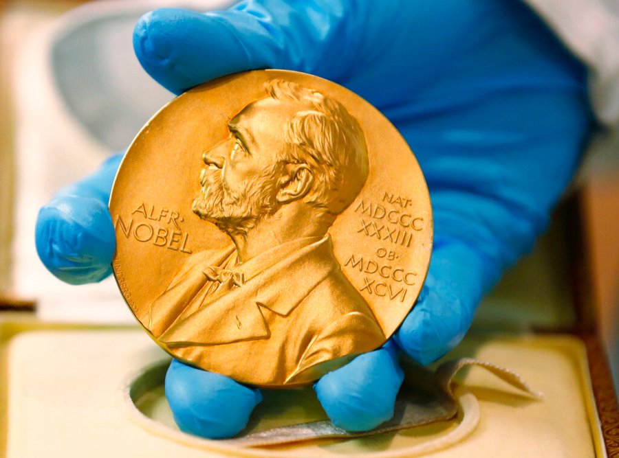 In this file photo dated Friday, April 17, 2015, a national library employee shows the gold Nobel Prize medal. (AP Photo/Fernando Vergara, File)