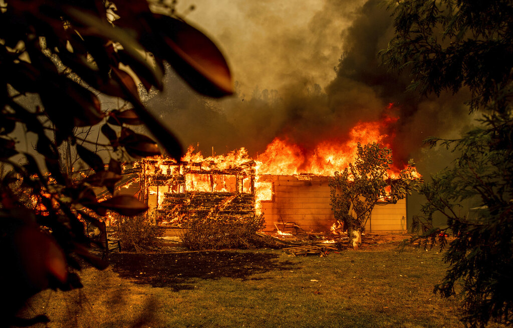 In this Sept. 23, 2021, file photo, flames consume a house near Old Oregon Trail as the Fawn Fire burns north of Redding in Shasta County, Calif. (AP Photo/Ethan Swope, File)