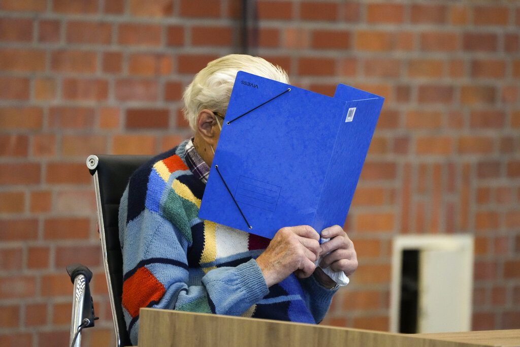 The accused Josef S. covers his face as he sits at the court room in Brandenburg, Germany, Thursday, Oct. 7, 2021. (AP Photo/Markus Schreiber)