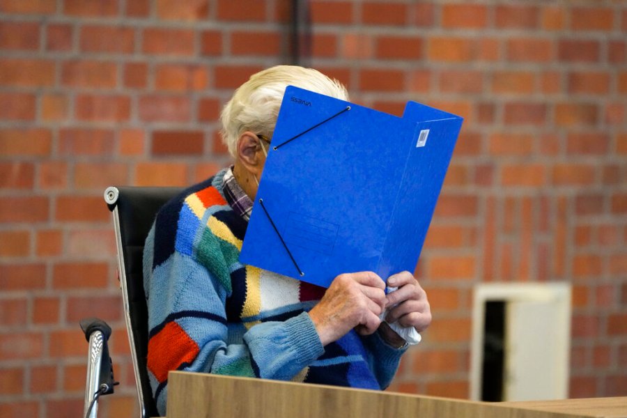 The accused Josef S. covers his face as he sits at the court room in Brandenburg, Germany, Thursday, Oct. 7, 2021. (AP Photo/Markus Schreiber)