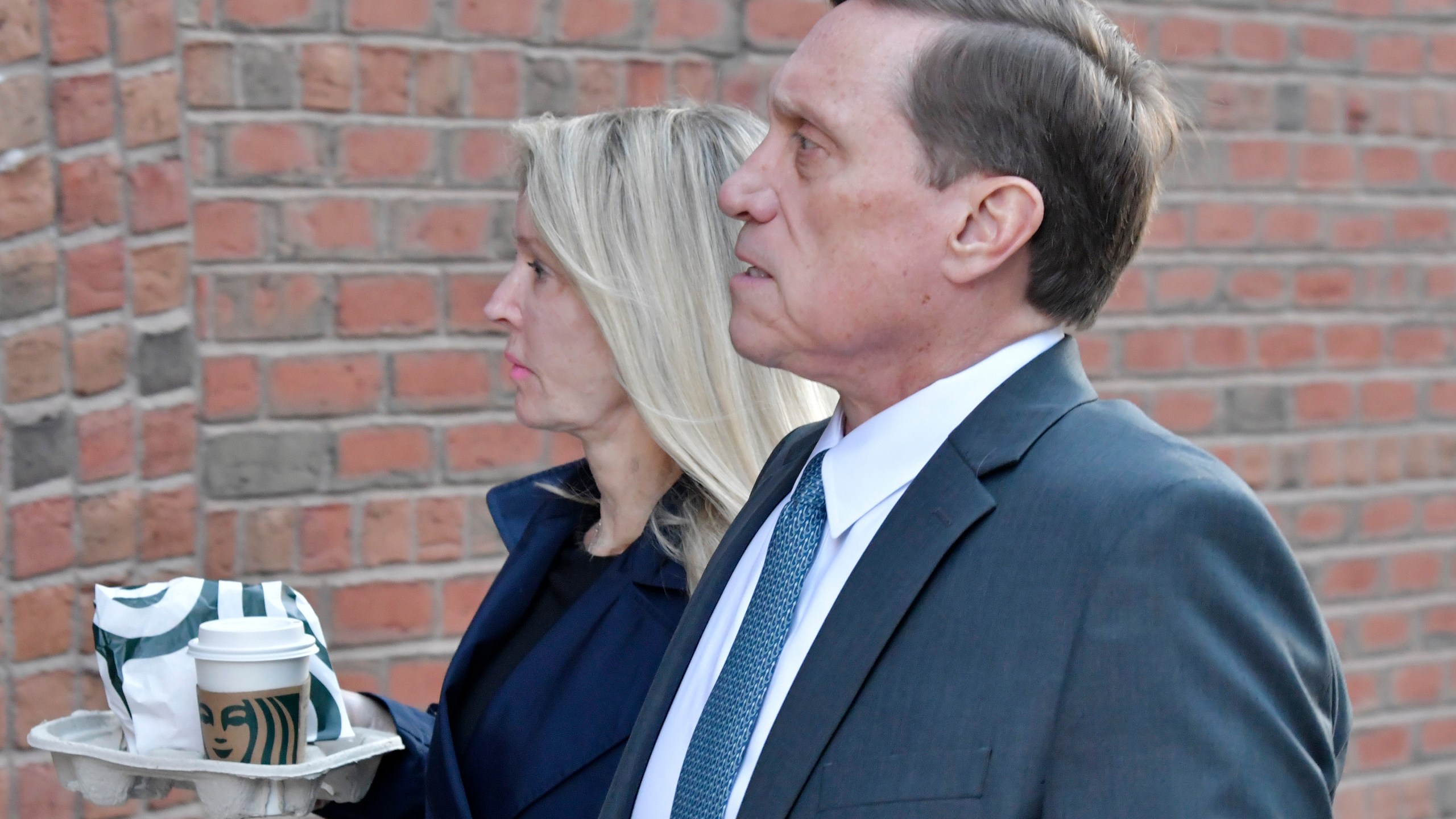 John Wilson and his wife arrive at federal court on Oct. 7, 2021, in Boston. Wilson and another parent Gamal Abdelaziz, are the first to stand trial in the college admissions bribery scandal, in which wealthy parents used lies and money to steal coveted spots at prestigious schools their kids couldn't secure on their own, according to a prosecutor. (AP Photo/Josh Reynolds)