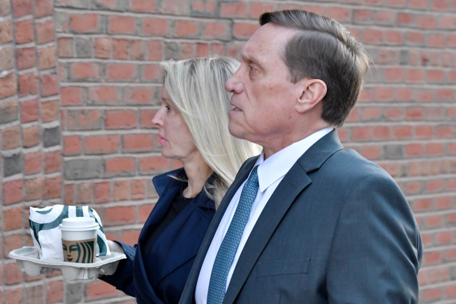 John Wilson and his wife arrive at federal court on Oct. 7, 2021, in Boston. Wilson and another parent Gamal Abdelaziz, are the first to stand trial in the college admissions bribery scandal, in which wealthy parents used lies and money to steal coveted spots at prestigious schools their kids couldn't secure on their own, according to a prosecutor. (AP Photo/Josh Reynolds)