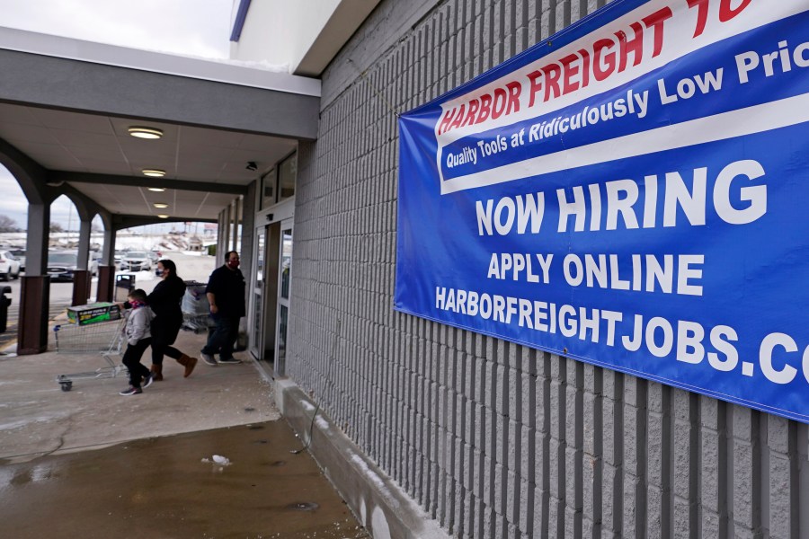 In this Dec. 10, 2020, file photo, a "Now Hiring" sign hangs on the front wall of a Harbor Freight Tools store in Manchester, N.H. When the U.S. government issues the September jobs report on Friday, Oct. 8, 2021, the spotlight will fall not only on how many people were hired last month. A second question will command attention, too: Are more people finally starting to look for work? (AP Photo/Charles Krupa, File)