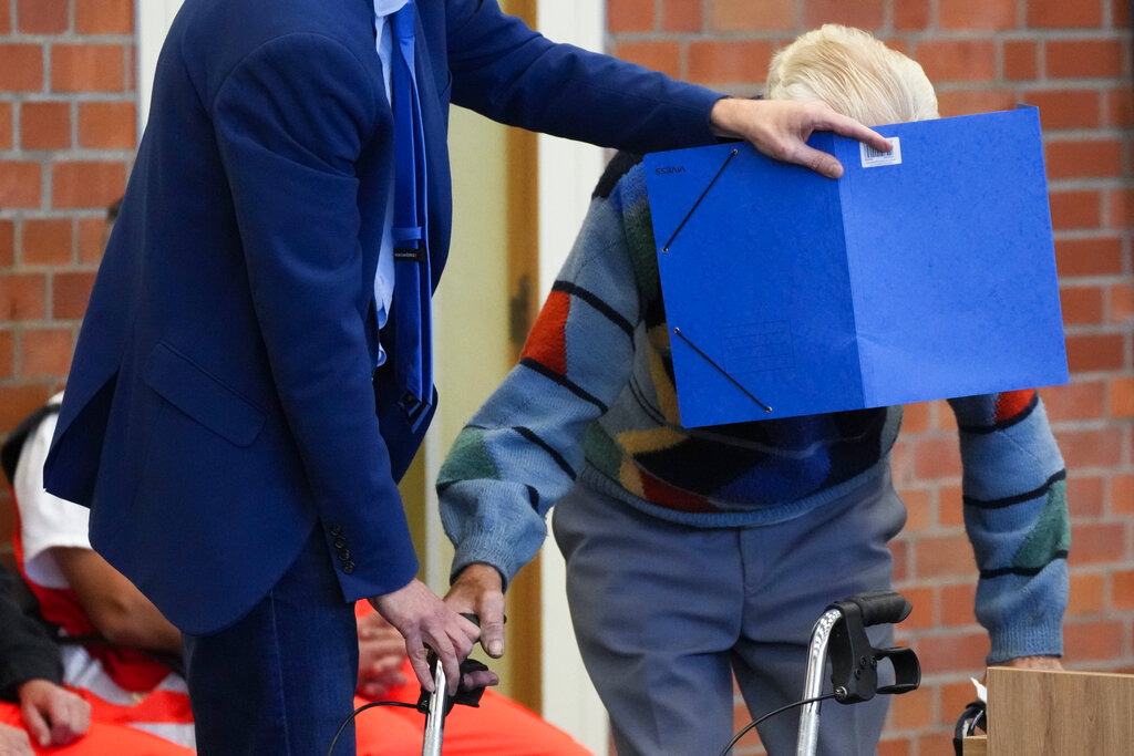 In this Thursday, Oct. 7, 2021 file photo, lawyer Stefan Waterkamp covers the face of accused Josef S. as they arrive at a courtroom in Brandenburg, Germany. (AP Photo/Markus Schreiber, File)