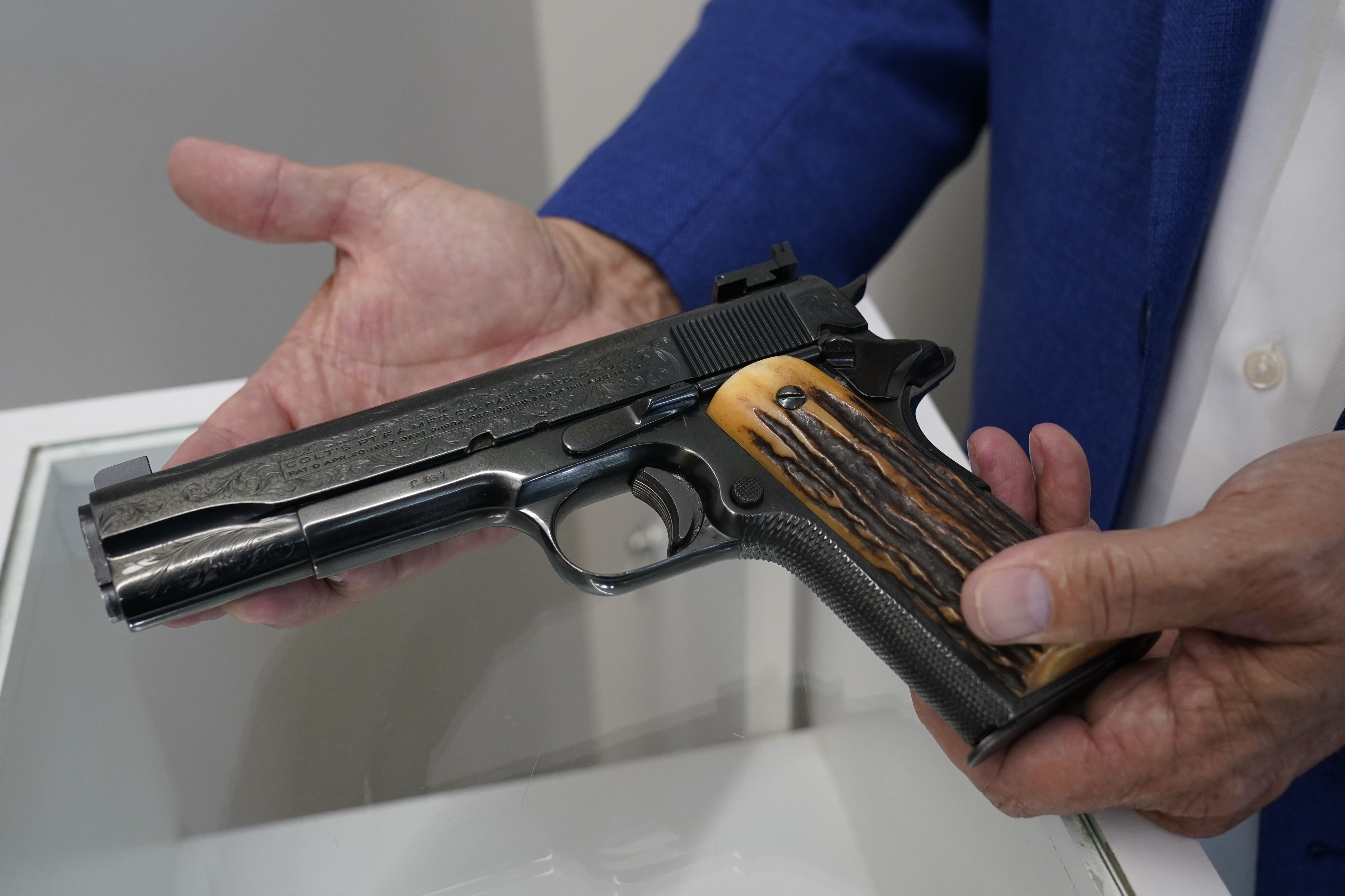 Brian Witherell displays a Colt .45-caliber pistol that once belonged to mob boss Al Capone, at Witherell's Auction House in Sacramento on Aug. 25, 2021. (Rich Pedroncelli / Associated Press)