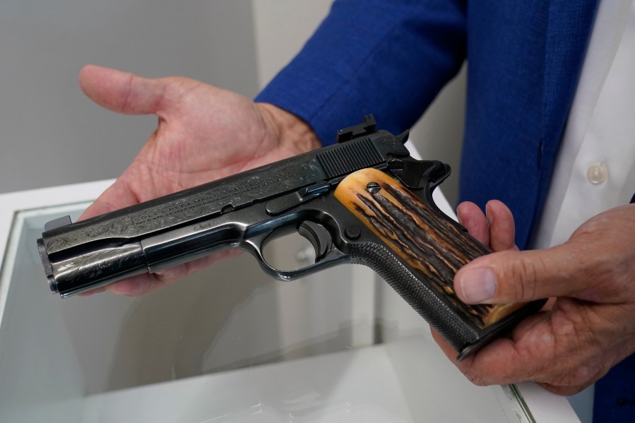 Brian Witherell displays a Colt .45-caliber pistol that once belonged to mob boss Al Capone, at Witherell's Auction House in Sacramento on Aug. 25, 2021. (Rich Pedroncelli / Associated Press)