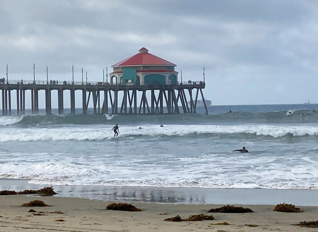 Surfers and swimmers return to the Huntington Beach pier waves since the crude oil spill at the California beach, Monday, Oct. 11, 2021. (AP Photo/Amy Taxin)