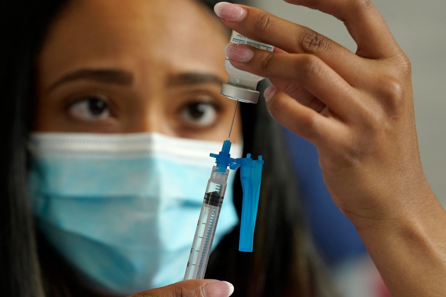 In this May 19, 2021, file photo, a licensed practical nurse draws a Moderna COVID-19 vaccine into a syringe at a mass vaccination clinic at Gillette Stadium in Foxborough, Mass. Starting Thursday, Oct. 14, 2021, the Food and Drug Administration convenes its independent advisers for the first stage in the process of deciding whether extra shots of Moderna or Johnson & Johnson vaccines should be dispensed and, if so, who should get them and when. (AP Photo/Steven Senne, File)