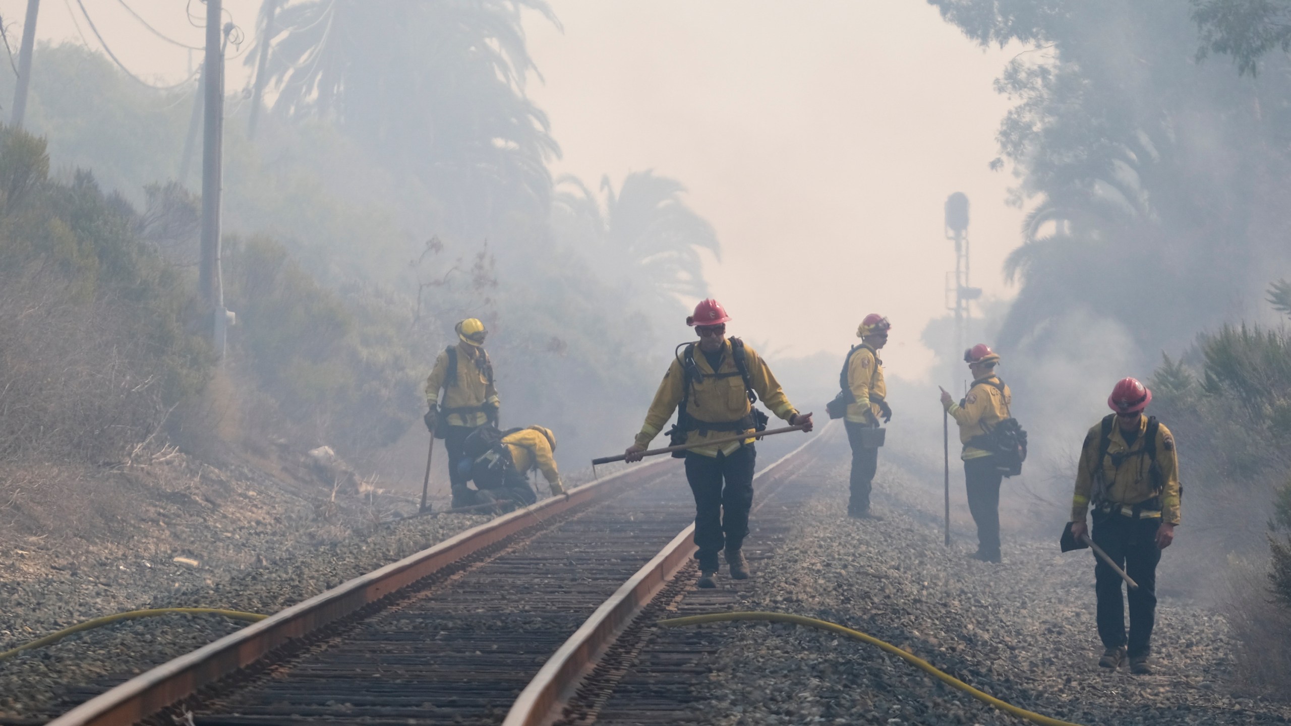 A firefighter watches on his fire engine as smoke rises from a wildfire Wednesday, Oct. 13, 2021, in Goleta, Calif.(AP Photo/Ringo H.W. Chiu)