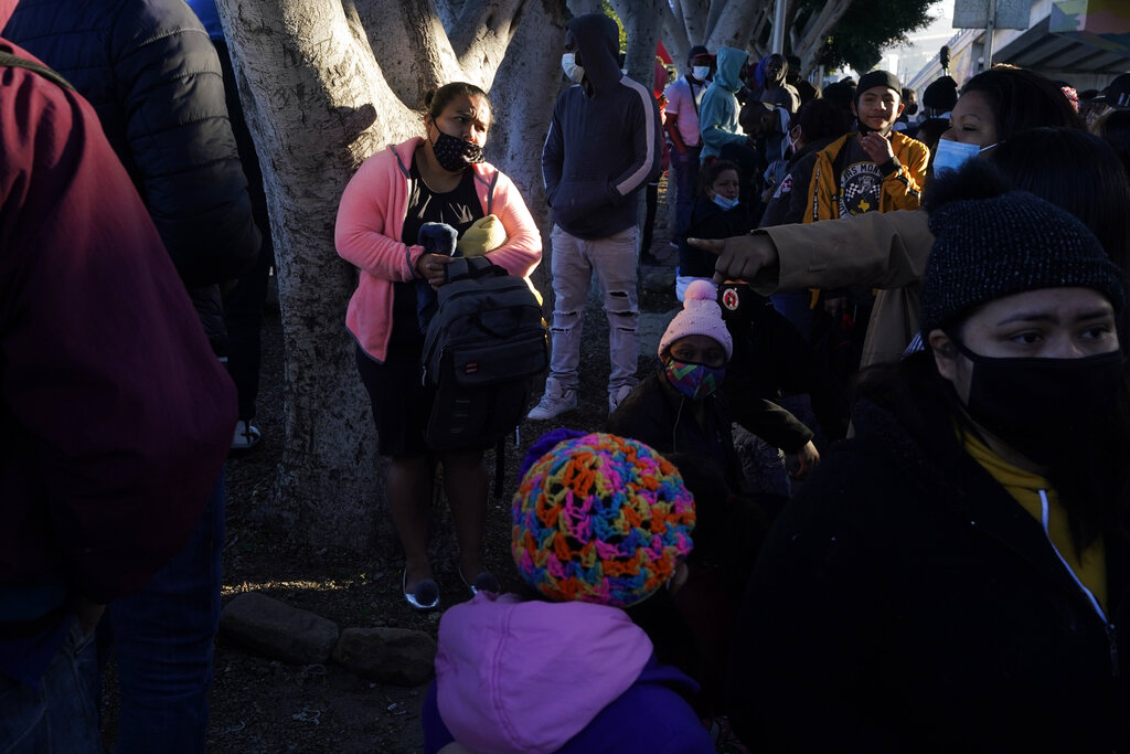 In this Feb. 19, 2021 file photo a woman seeking asylum in the United States waits with others for news of policy changes, in Tijuana, Mexico. (AP Photo/Gregory Bull, File)