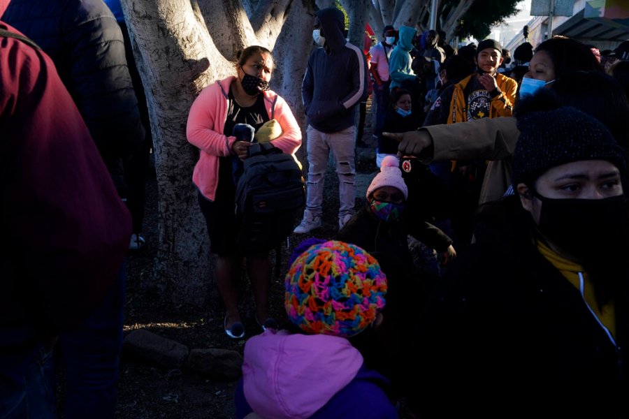 In this Feb. 19, 2021 file photo a woman seeking asylum in the United States waits with others for news of policy changes, in Tijuana, Mexico. (AP Photo/Gregory Bull, File)