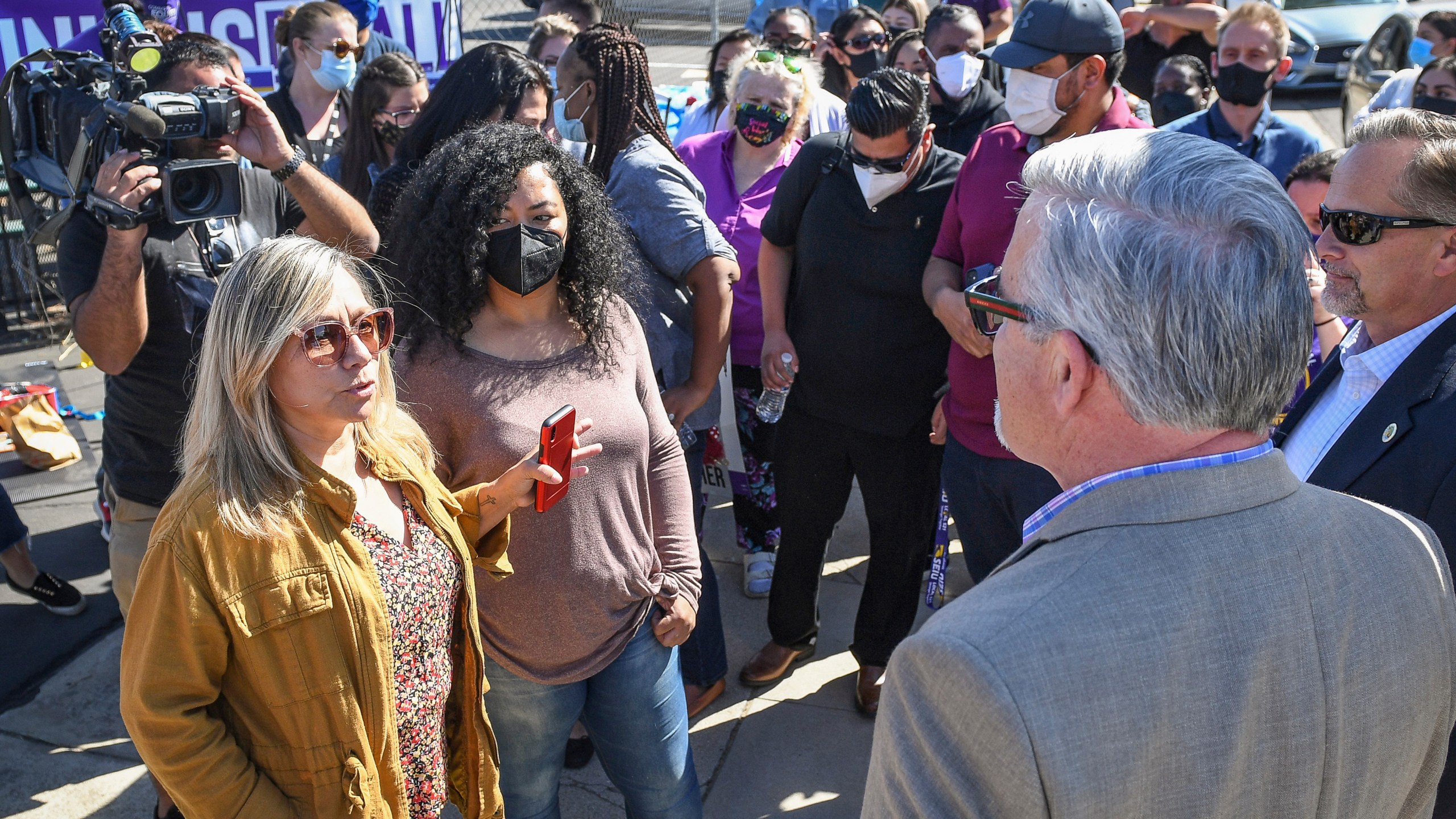 Fresno County social worker Lorraine Ramirez, left, discusses the situation with housing foster youth within the Child Protective Services office in downtown Fresno, Calif., with Fresno County Administrative Officer Jean Rousseau, right, during a demonstration and news conference by social workers represented by SEIU Local 521 on Thursday, Oct. 14, 2021. Rousseau is vowing changes after a news report revealed that some children removed from their families and into state care were living in deplorable conditions at the main child protective office, sleeping on conference tables and urinating into water bottles. (Craig Kohlruss/The Fresno Bee via AP)