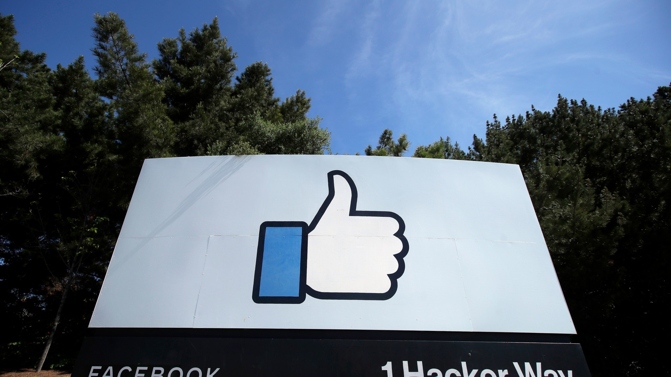 In this April 14, 2020 file photo, the thumbs up Like logo is shown on a sign at Facebook headquarters in Menlo Park, Calif. Facebook says it plans to hire 10,000 workers in the European Union over the next five years to work on a new computing platform. The company said in a blog post Sunday, Oct. 17, 2021 that those high-skilled workers will help build “the metaverse,” a futuristic notion for connecting people online that uses augmented and virtual reality. (AP Photo/Jeff Chiu, File)