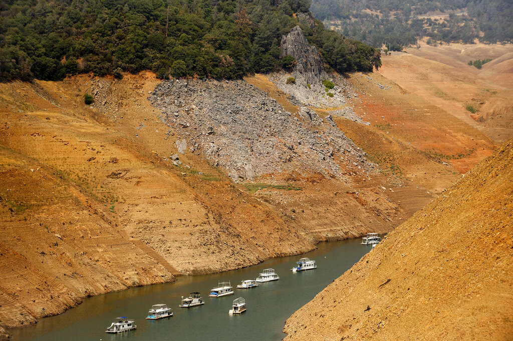 In this Aug. 14, 2021, file photo, houseboats rest in a channel at Lake Oroville State Recreation Area in Butte County, Calif. (AP Photo/Noah Berger, File)