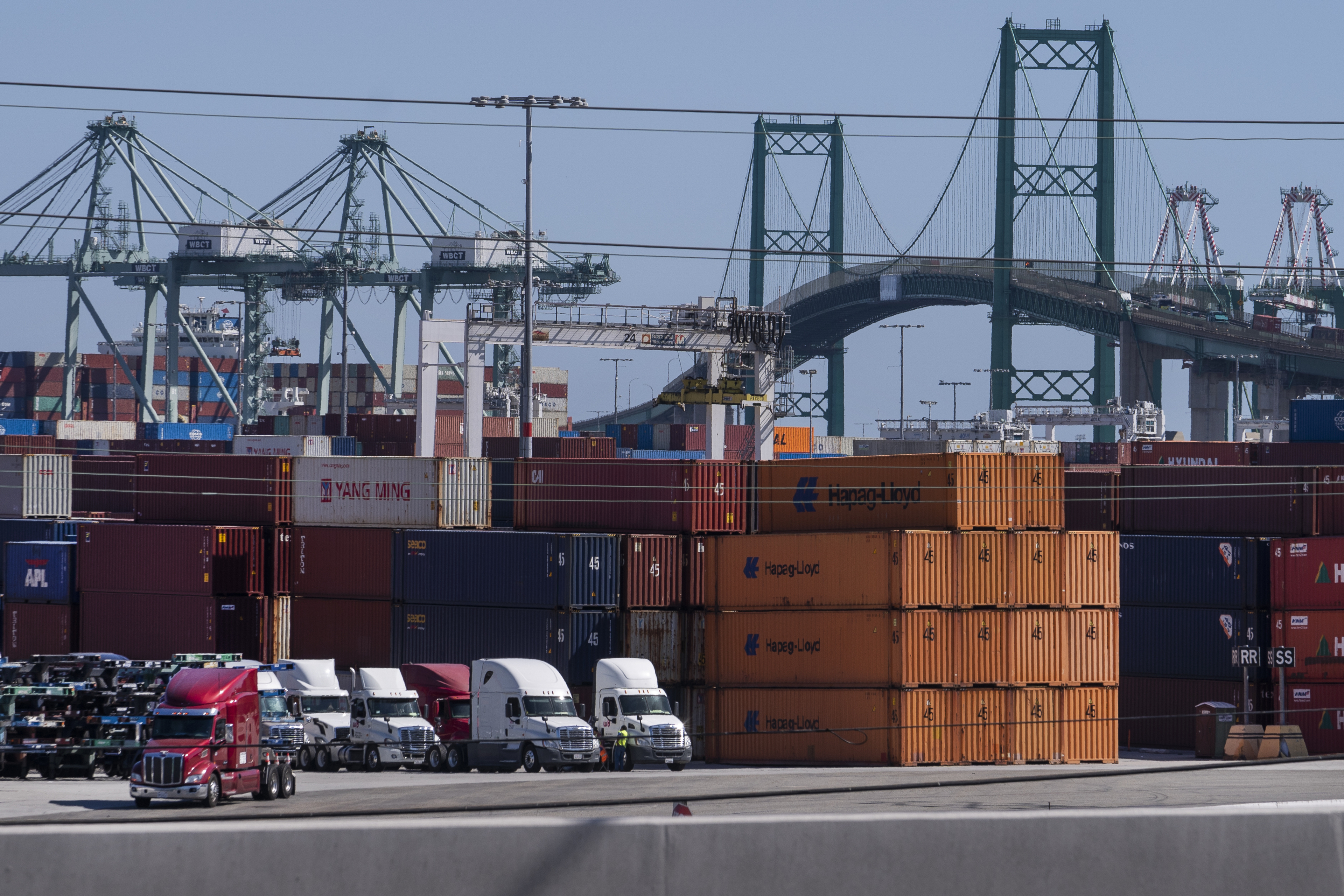 In this Oct. 19, 2021, photo trucks line up next to containers at the Port of Los Angeles in san Pedro, Calif. (AP Photo/Damian Dovarganes)