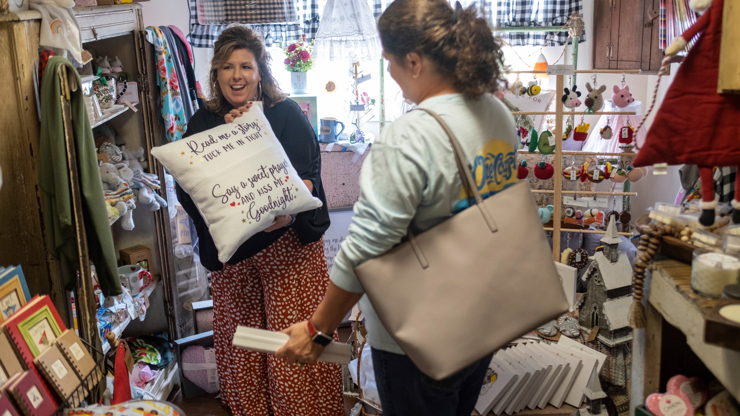 Ginger Pigg suggests a gift to a customer in her gift boutique The Perfect Pigg in Cumming, Ga. on Thursday afternoon, Oct. 22, 2021. She says she is struggling to get products to her store in a timely way. (AP Photo/Ben Gray)