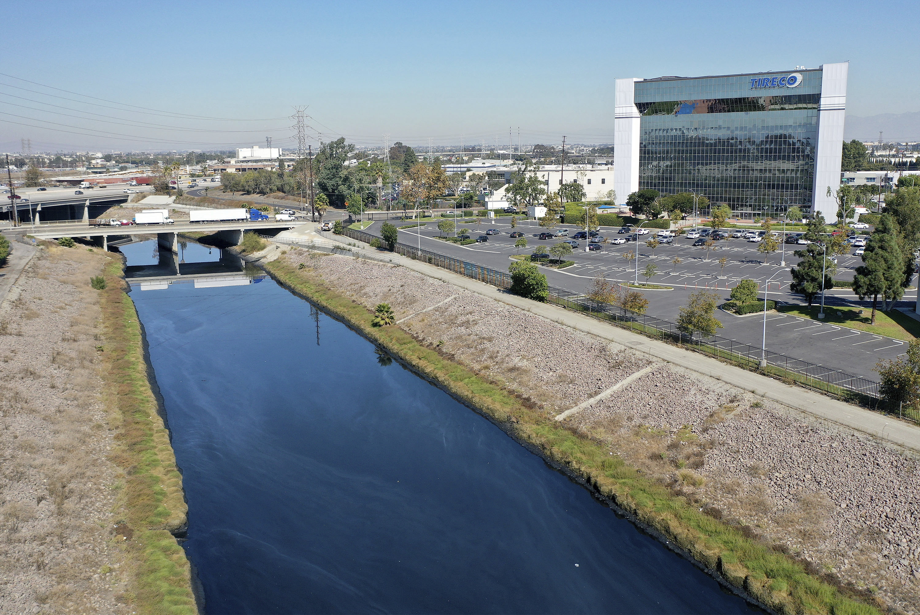 This Thursday, Oct. 21, 21021, aerial image taken with a drone, shows the Dominguez Channel flowing through Carson, Calif. Levels of wretched-smelling hydrogen sulfide gas that have plagued south Los Angeles County communities for weeks are declining as authorities use various mitigation methods in a flood control channel emitting the gross odors, officials said Friday. (Dean Musgrove/The Orange County Register via AP)