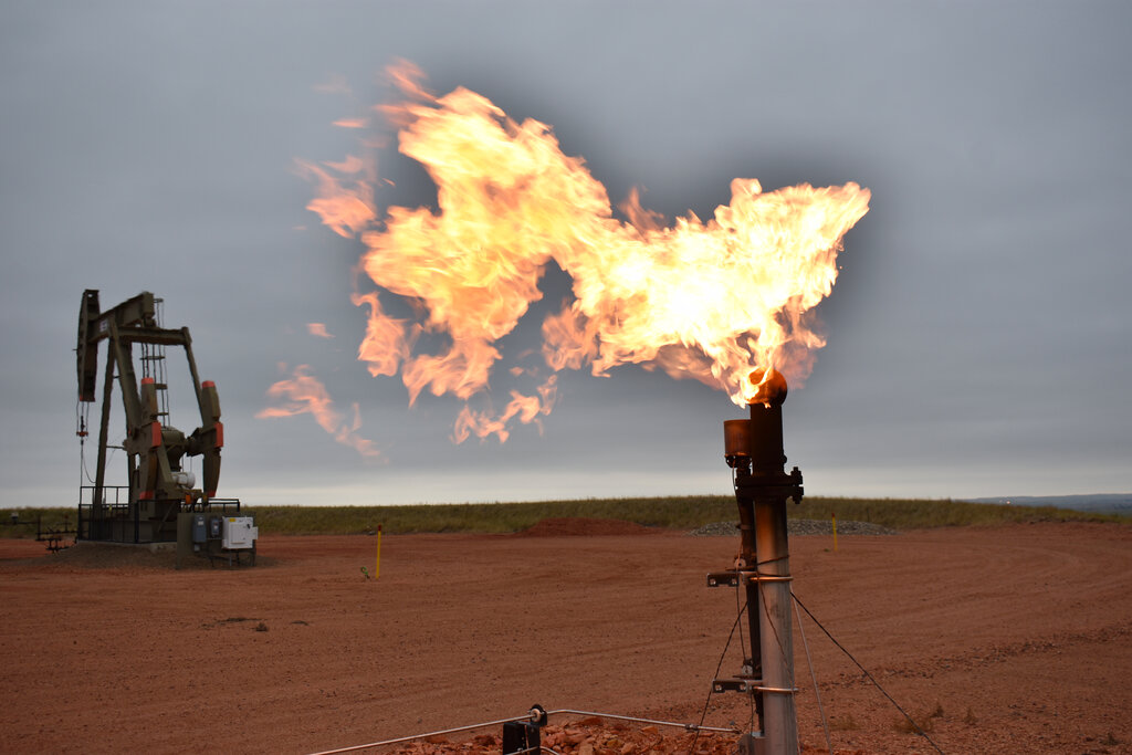 A flare burns natural gas at an oil well on Aug. 26, 2021, in Watford City, United States. (AP Photo/Matthew Brown, File)