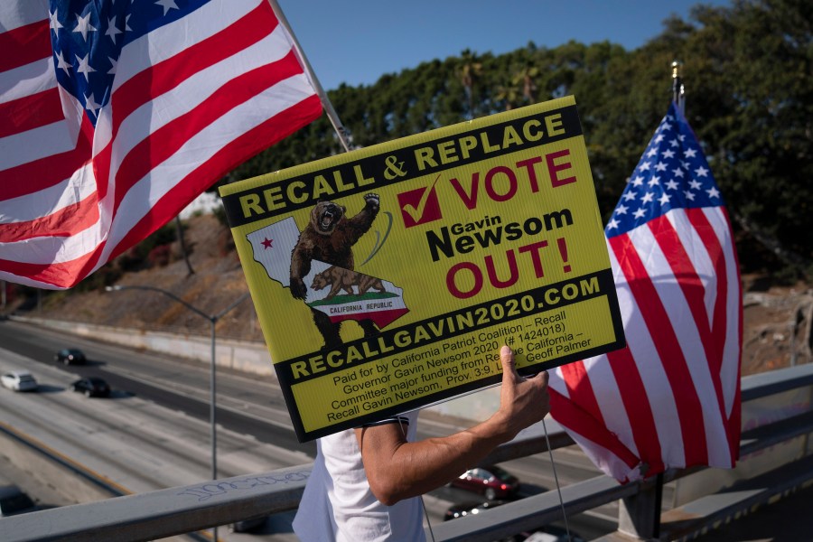 Zig Jiang, 47, carries a sign calling for a recall on California Gov. Gavin Newsom on a bridge overlooking the 101 Freeway, Wednesday, Sept. 8, 2021, in Los Angeles. Weeks after Gov. Newsom fended off an attempt to remove him from office in mid-term, his fellow Democrats on Thursday, Oct. 28, 2021, began eyeing ways to make future challenges more difficult. (AP Photo/Jae C. Hong)