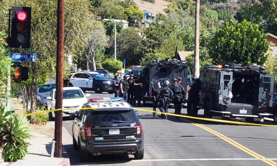 LAPD officers surround a home in the Cypress Park neighborhood of northeast Los Angeles on Oct. 28, 2021, after a resident said a man was at the property illegally.(Nathan Solis / Los Angeles Times)