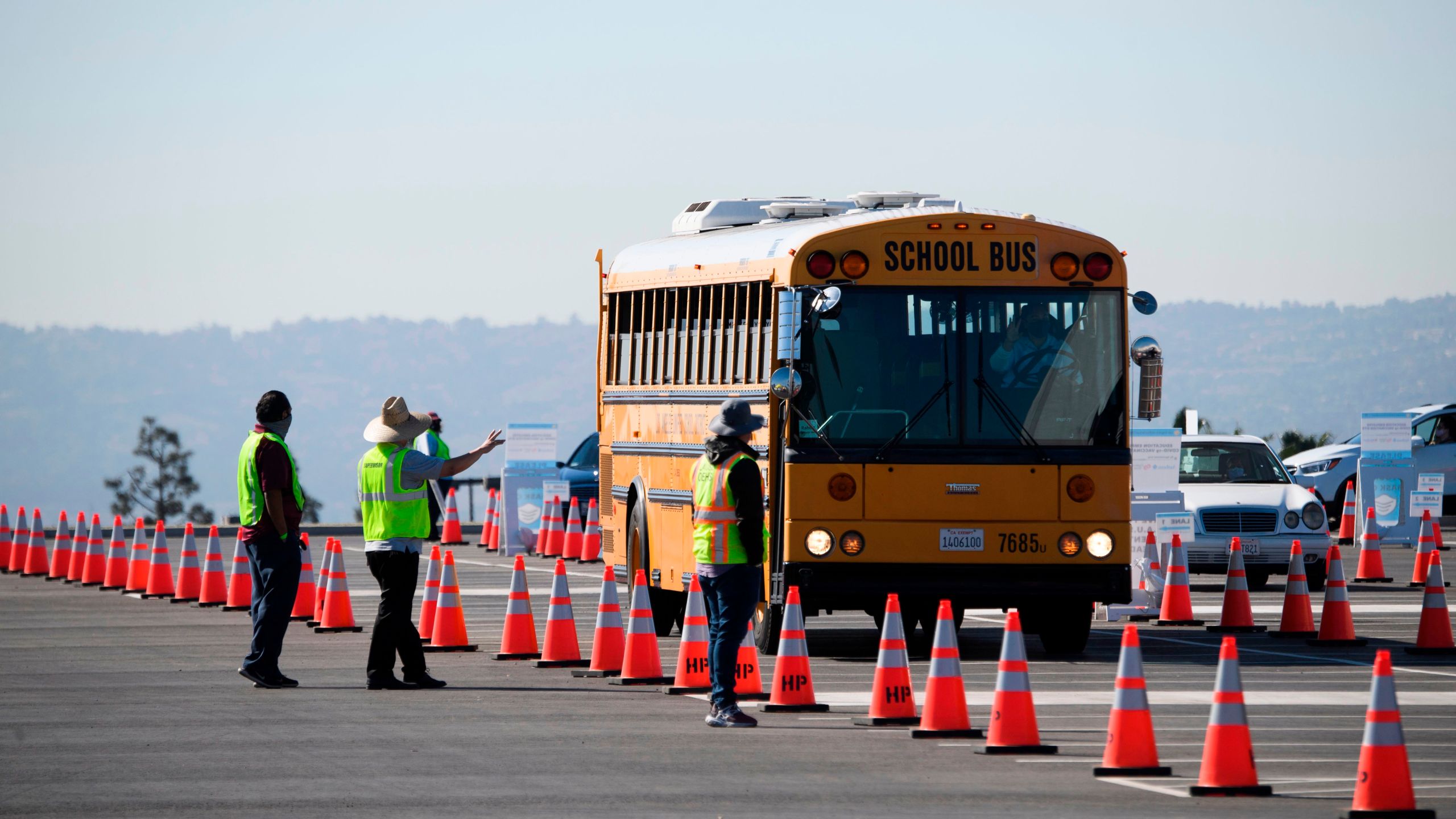 A school bus transporting education workers arrives at a mass vaccination site near SoFi stadium on March 1, 2021 in Inglewood. (PATRICK T. FALLON/AFP via Getty Images)